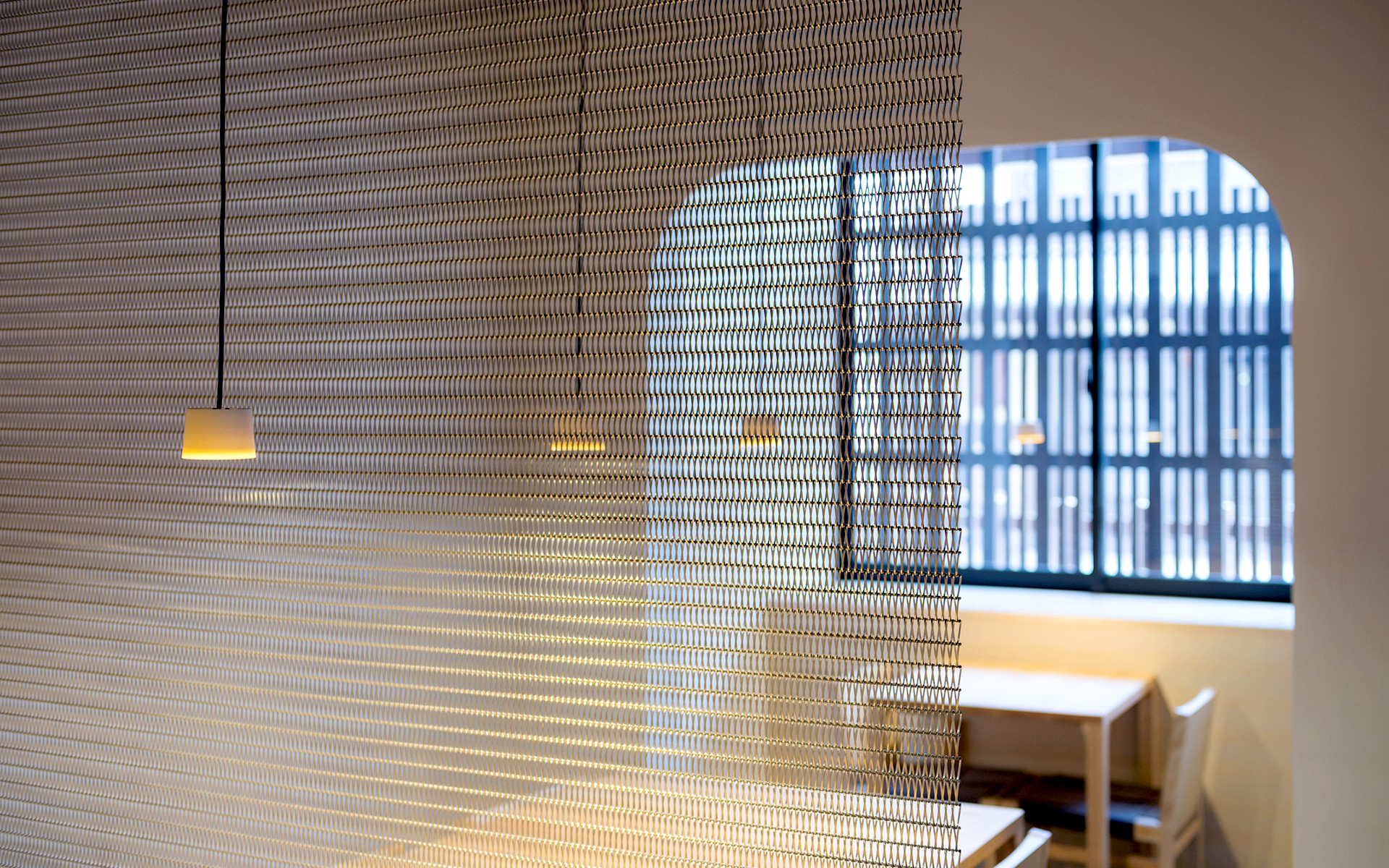 和食店「IZAMA」ではテーブル間の仕切りにステンレスメッシュを採用。そのデザインは簾から発想した