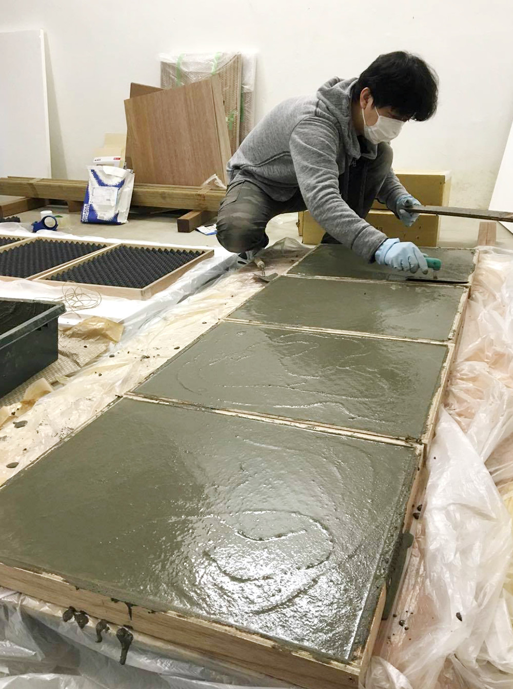 ワープゾーンの床タイルの製作風景。左側に見える木枠の黒いものが「型」で、壁面や天井面より凸凹が1段階小さい吸音材を使用。これに厚さ約30ミリまでモルタルを塗り重ねた(写真:GENETO)