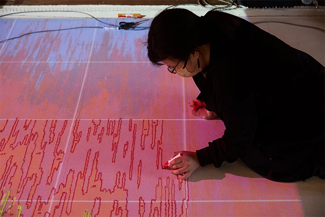1. 下地となる布にプロジェクター等でデザイン画を投影し、布地に下絵を描く